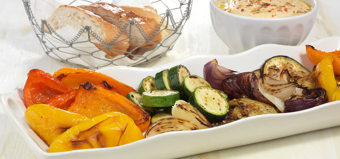 Roasted vegetables with hummus in serving dish