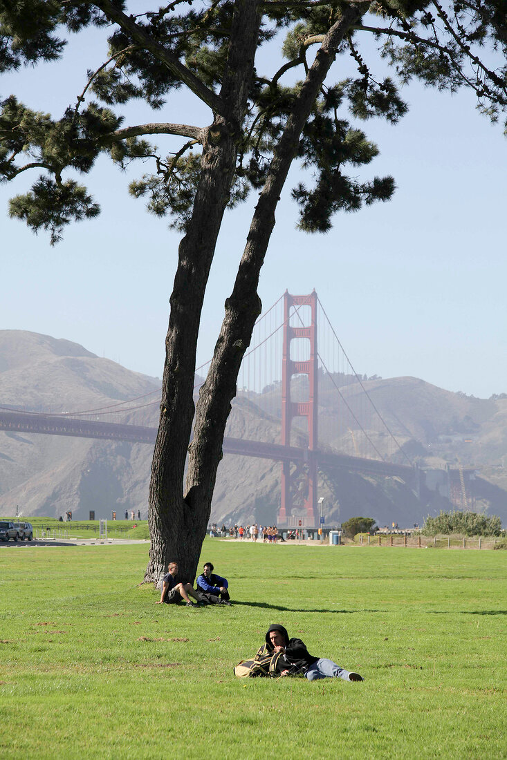 People in lawn area against Golden Gate Bridge, San Francisco, California, USA