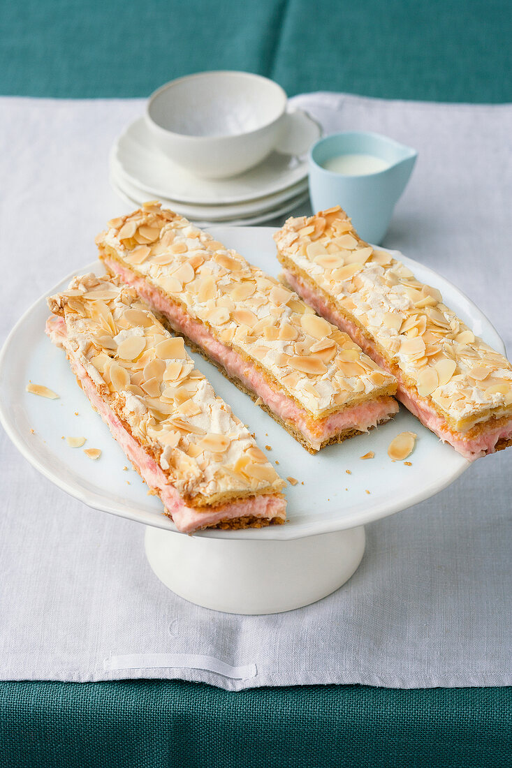 Sliced rhubarb meringue pie sheet cake on cake stand