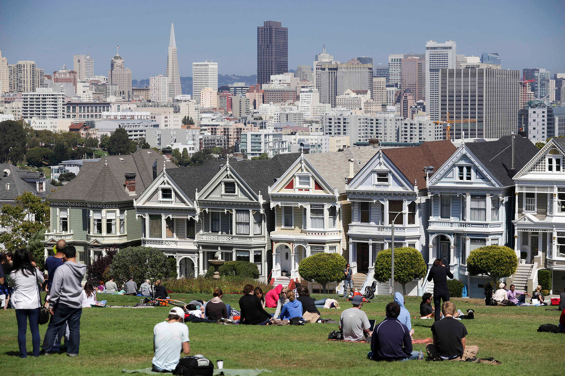 People at meadow in front of postcard row in San Francisco, California, USA