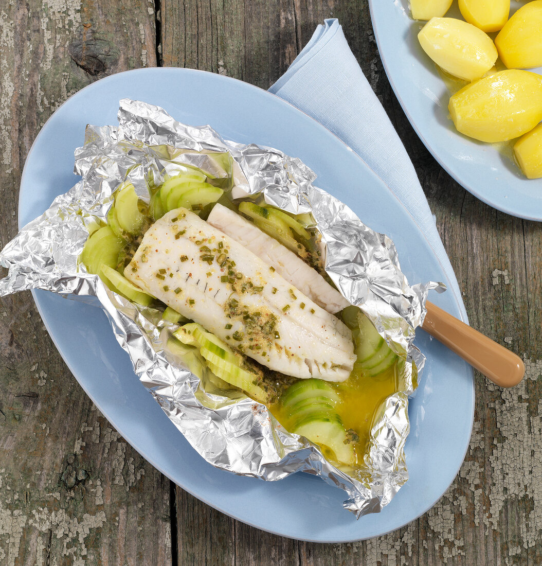 Foil fish with mustard butter on plate