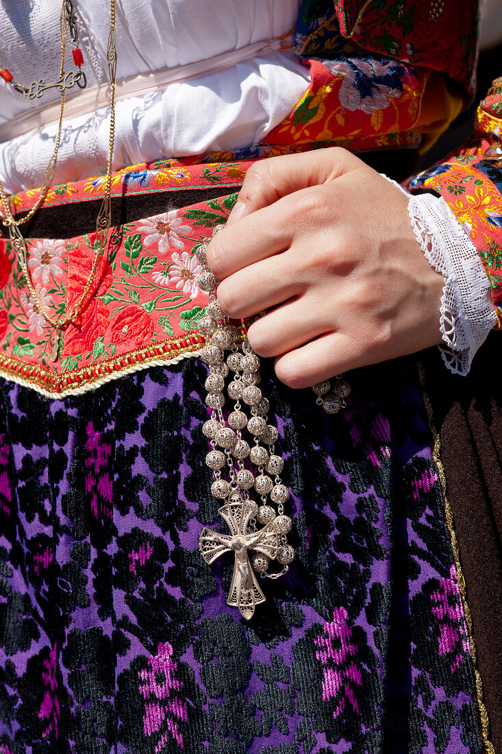 Close-up of woman holding rosary at Cagliari's Sant 'Efisio, Sardinia, Italy