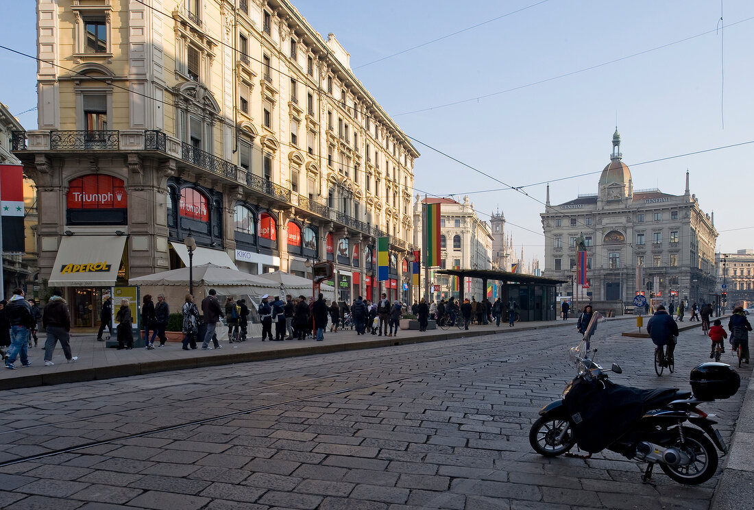 View of Generali building and street with people in Milan, Italy