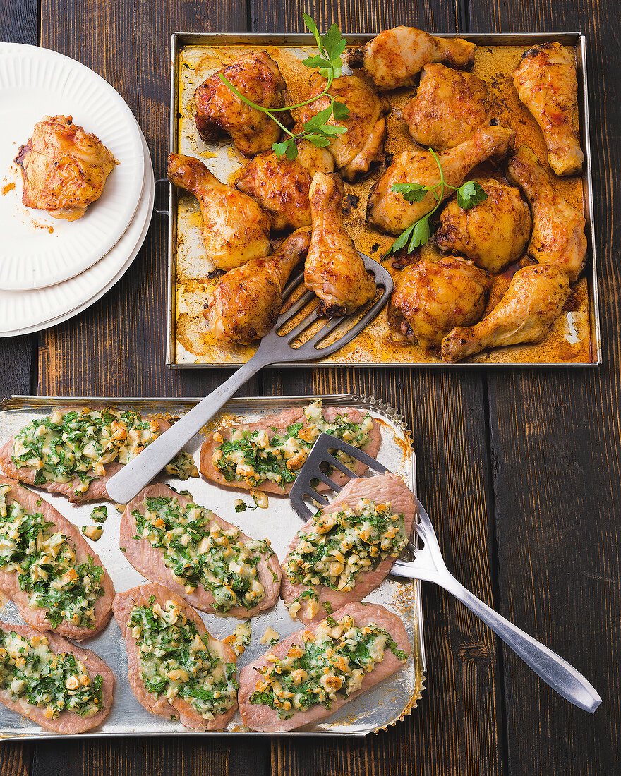 Chicken legs and oven steak with parmesan crust on baking tray