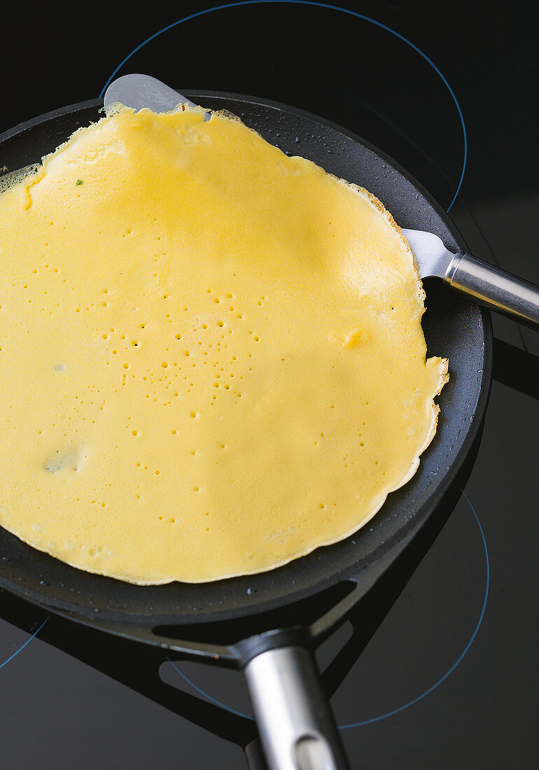 Close-up of crepe being made on pan, step 1