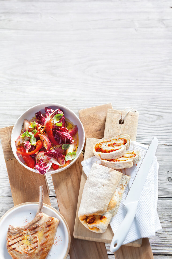 Radicchio and peach salad with peppers in bowl and grilled pesto and mozzarella ciabatta