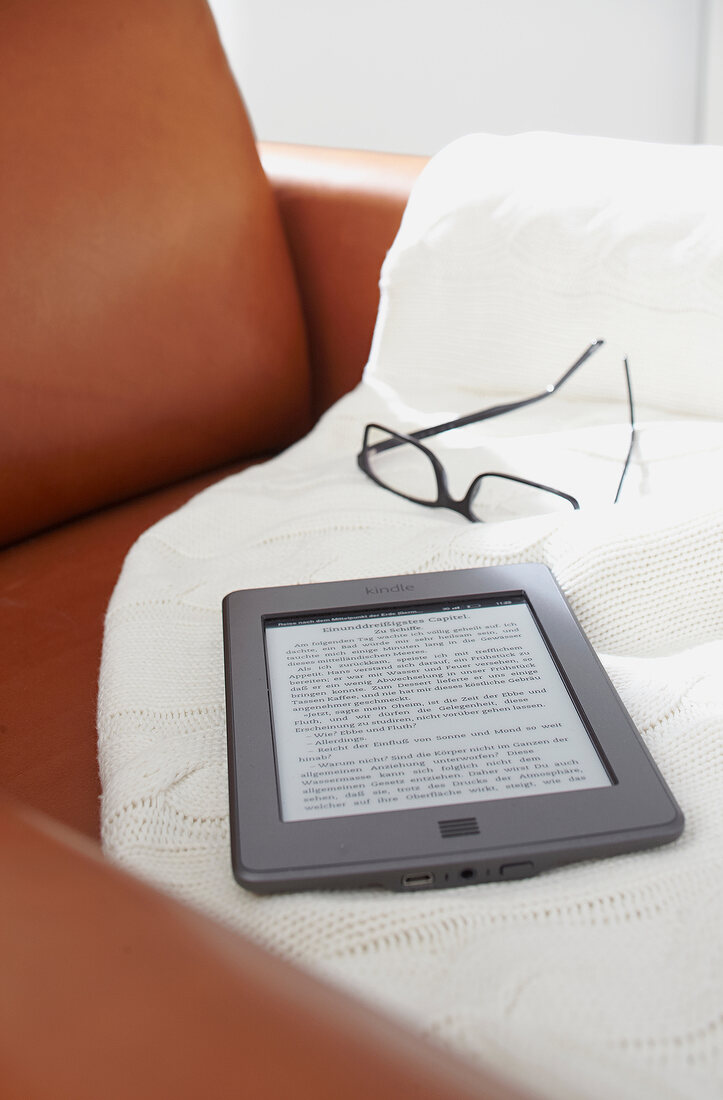 Glasses and e-book reader on white cloth