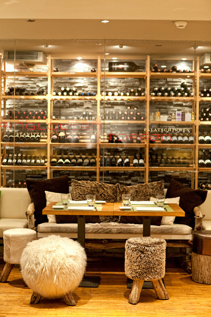 Equipment with tripod stool, fur and wine rack in restaurant, Tschebull