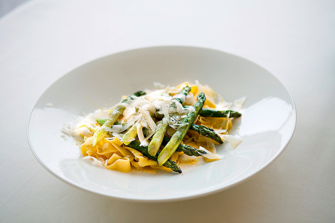 Pasta with green asparagus and parmesan on plate