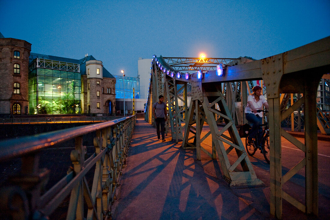 People walking on bridge in front of Stollwerk Chocolate Museum, Cologne, Germany