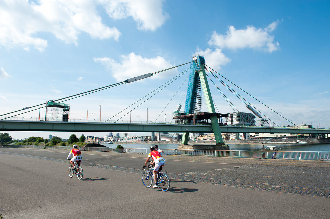 Cyclists on street near Severin Bridge, Rhine, Cologne, Germany