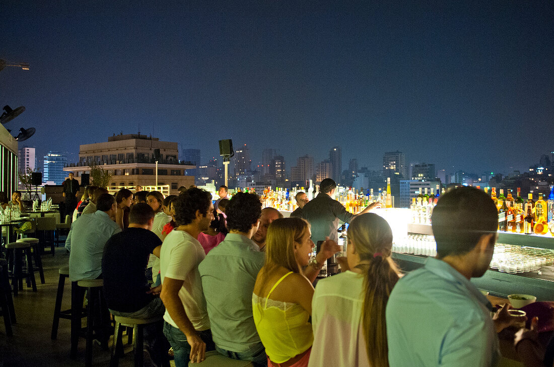People sitting on rooftop bar Le Capitole overlooking city of Beirut, Lebonan