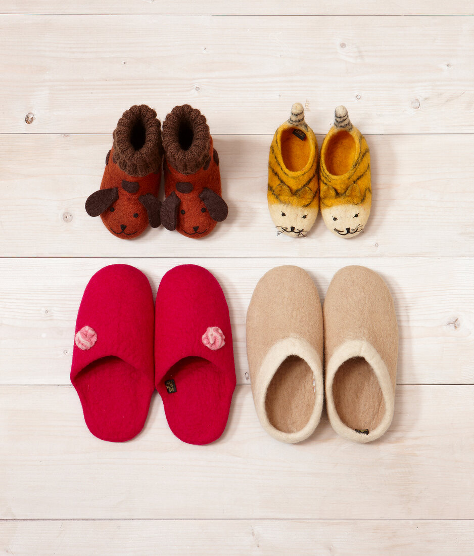 Various felt slippers on wooden background