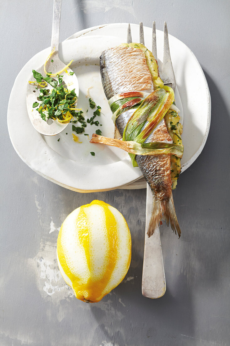 Fried herring filled with gremolata and lemon on plate