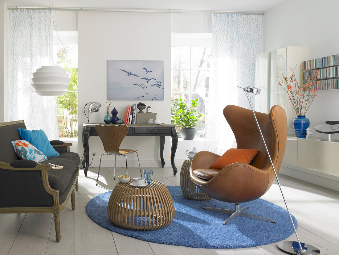 Living room with brown sofa, desk chair and floor lamp