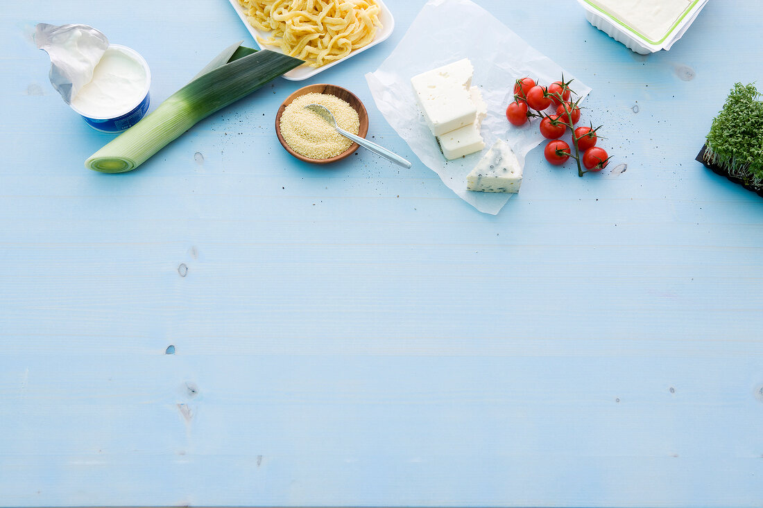 Vegetables, milk products and noodles on blue background