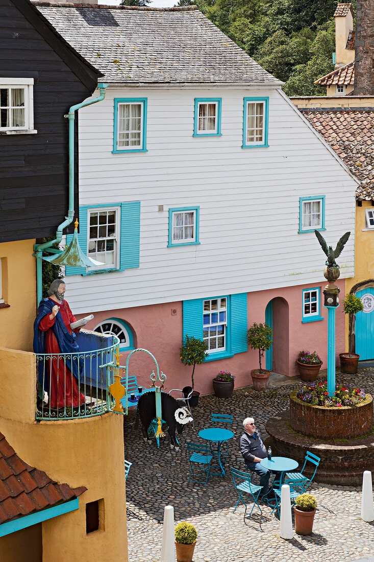 Man sitting in outdoors cafe in Battery Square, Portmeirion, Wales