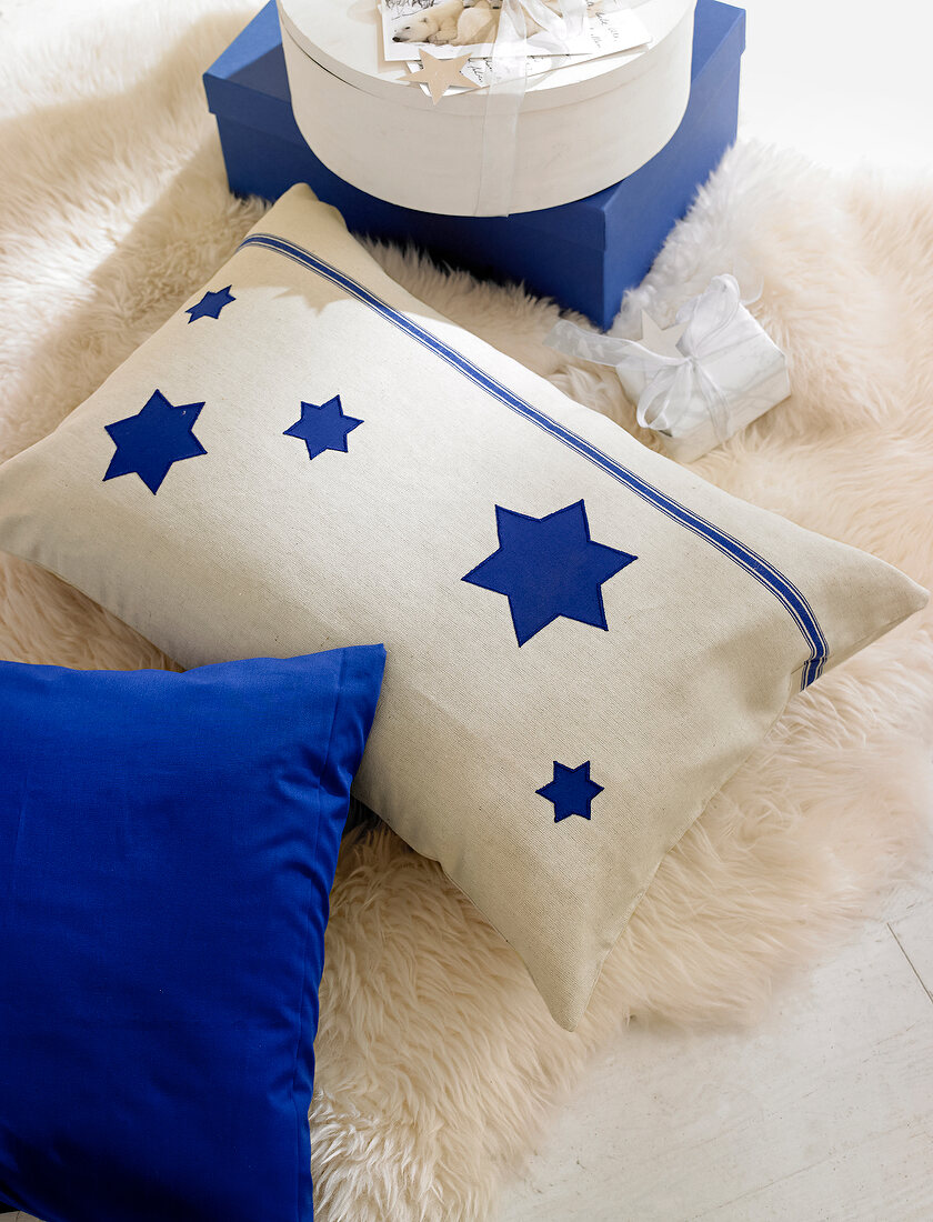 Beige pillow with star motif on white carpet