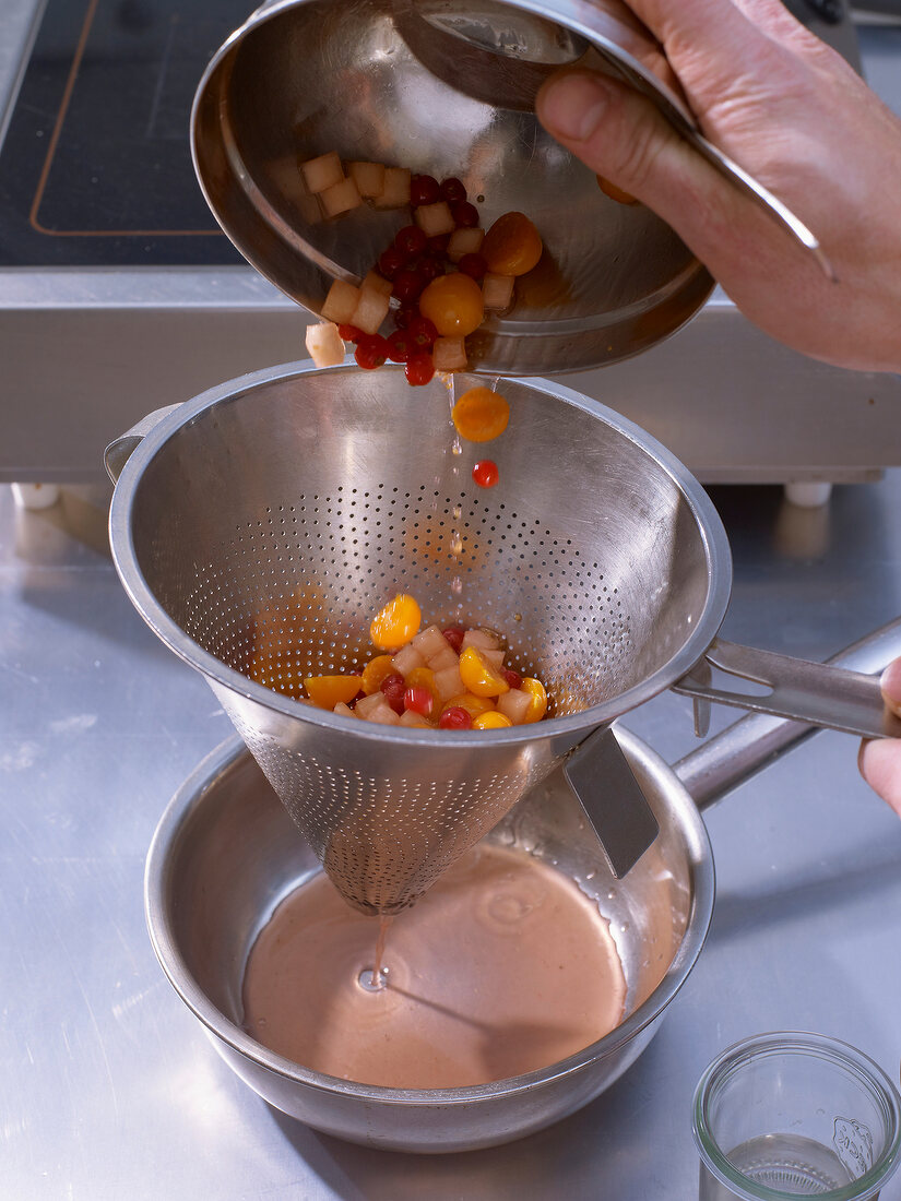 Straining juice from fruits through sieve