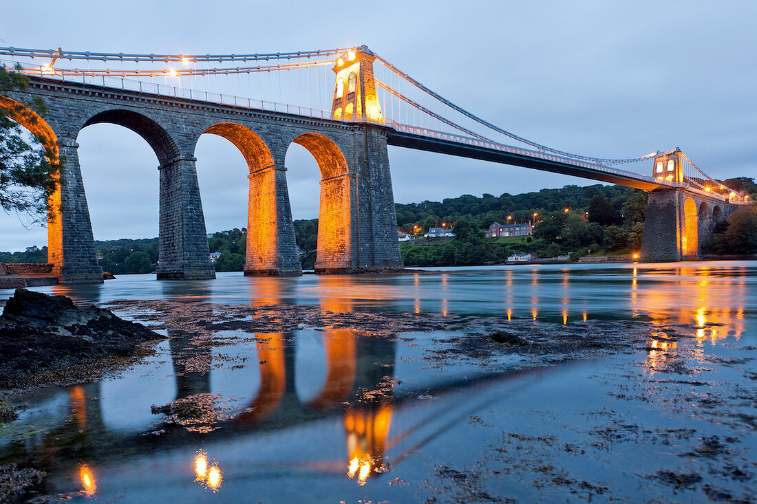 View of Illuminated Menai Bridge at dusk in Anglesey, Wales, UK