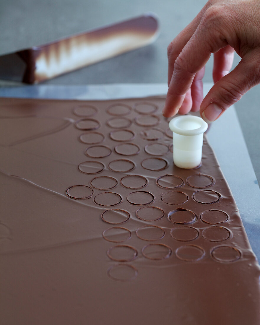 Small circles being cut with cutter on spread chocolate, step 2