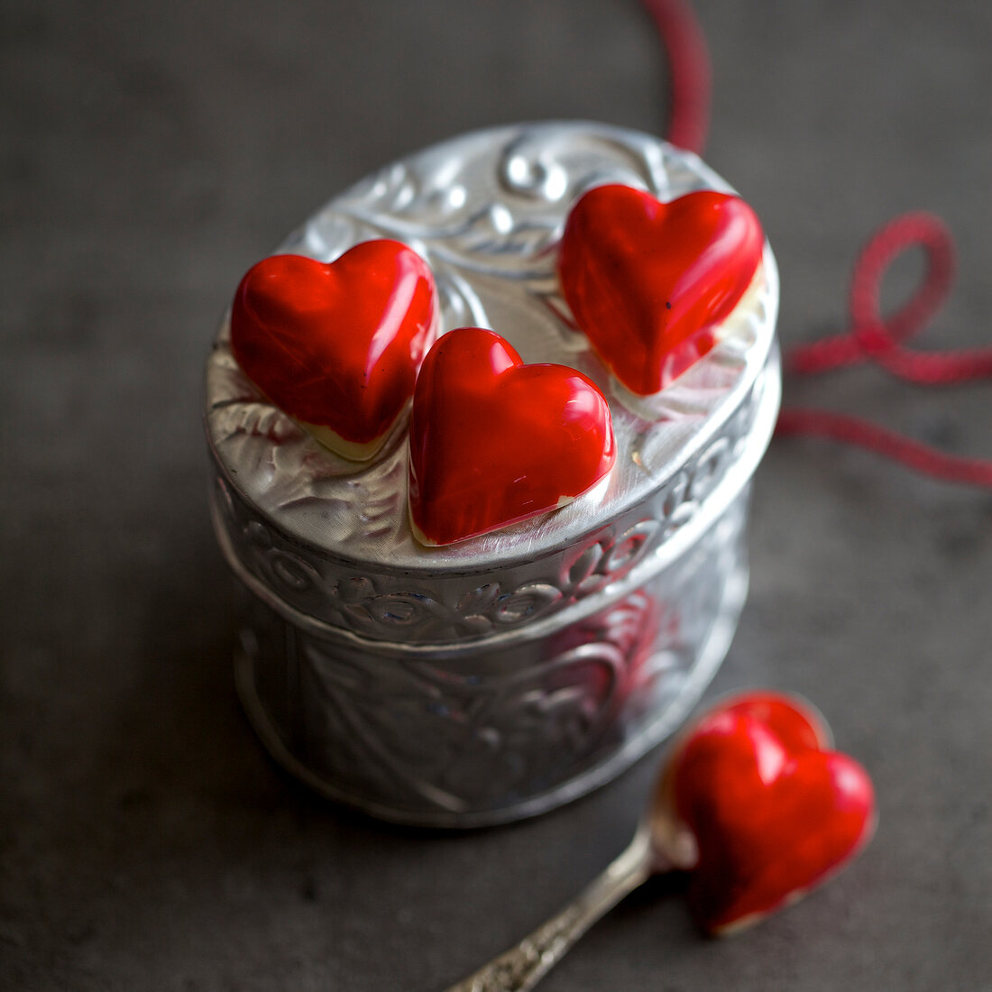 Heart shaped red chocolates on silver box