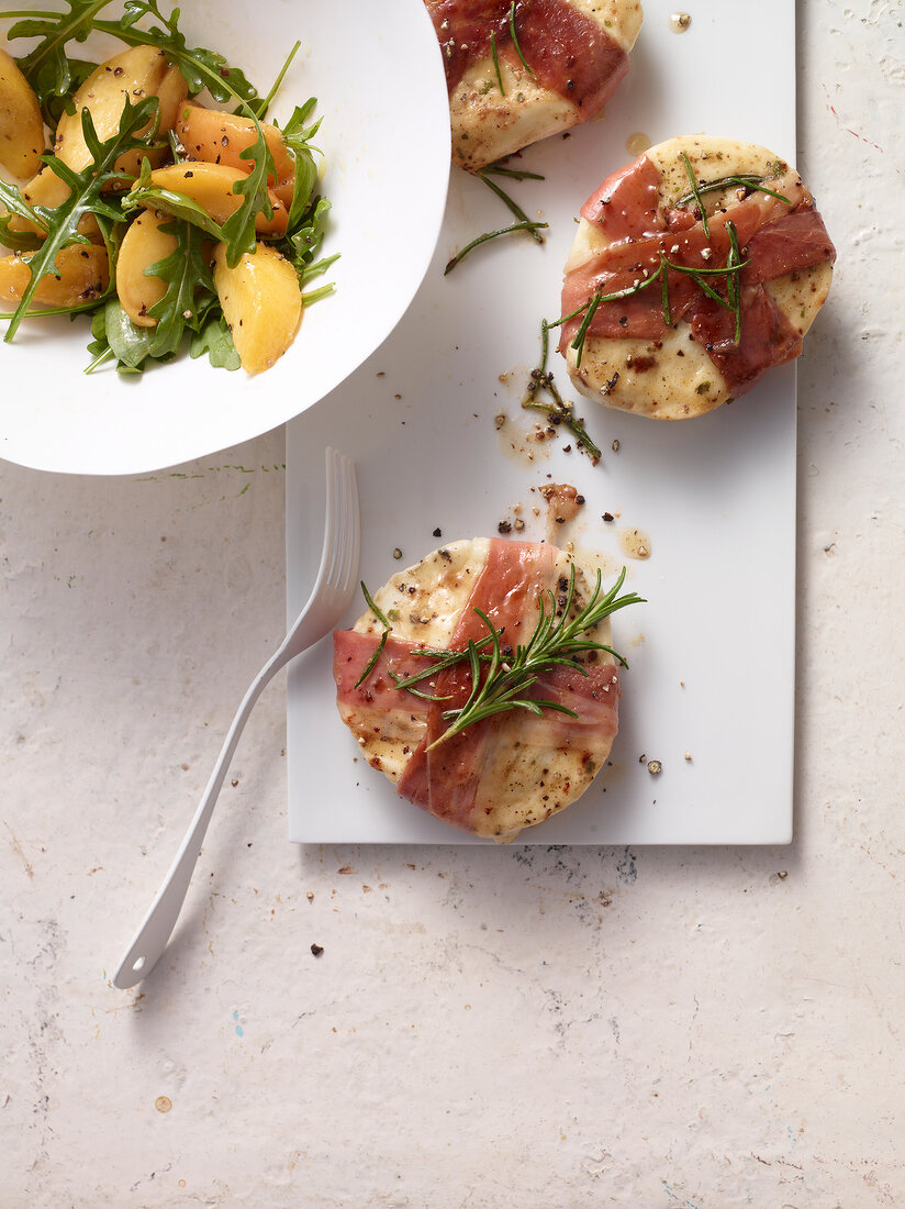 Mozzarella and ham parcels with rocket-peach salad, overhead view