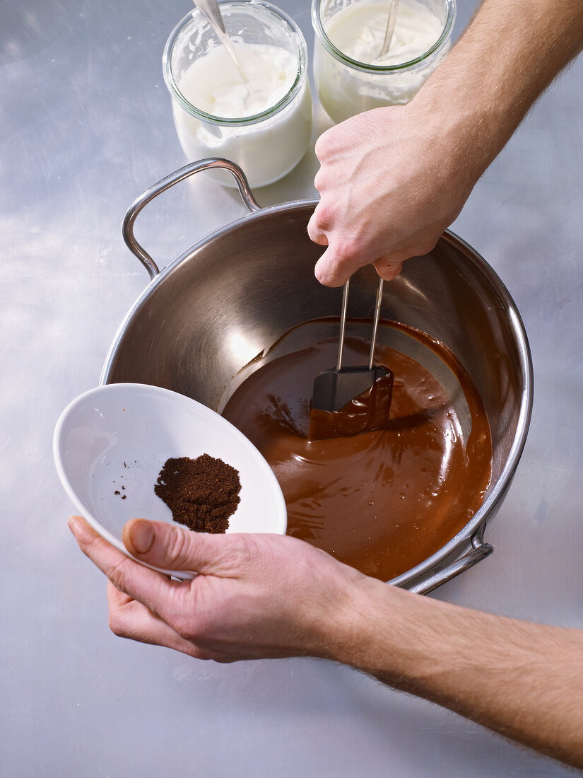 Adding triturated pepper to melted chocolate in bowl
