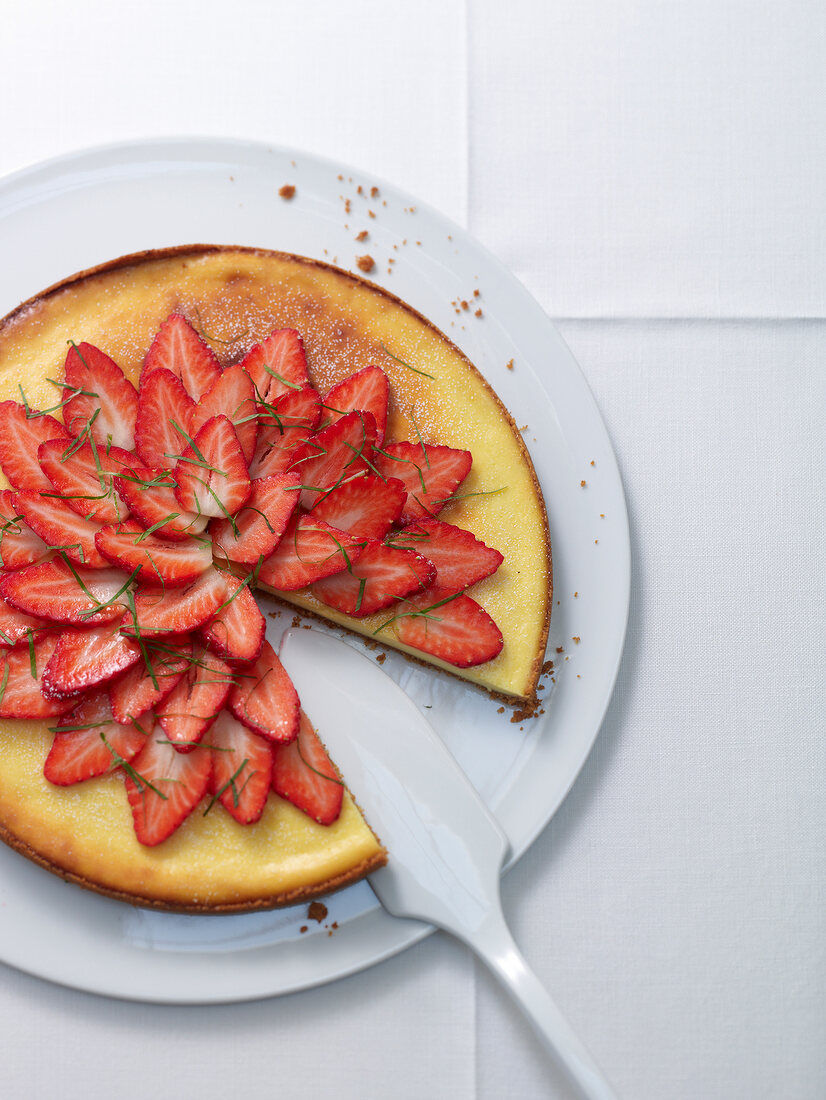 Ricotta cheesecake with strawberries on plate, overhead view