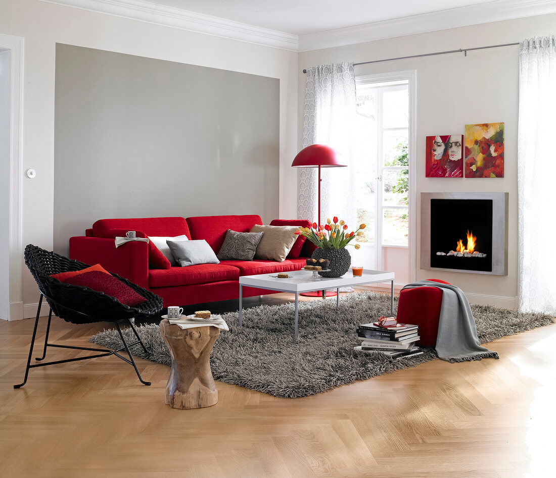 Living room with fireplace, red sofa, rug and table