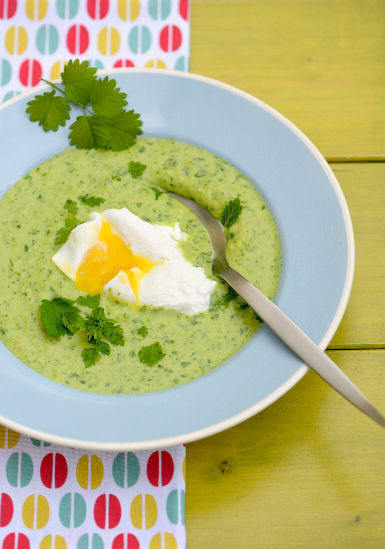 Coriander soup with egg on plate
