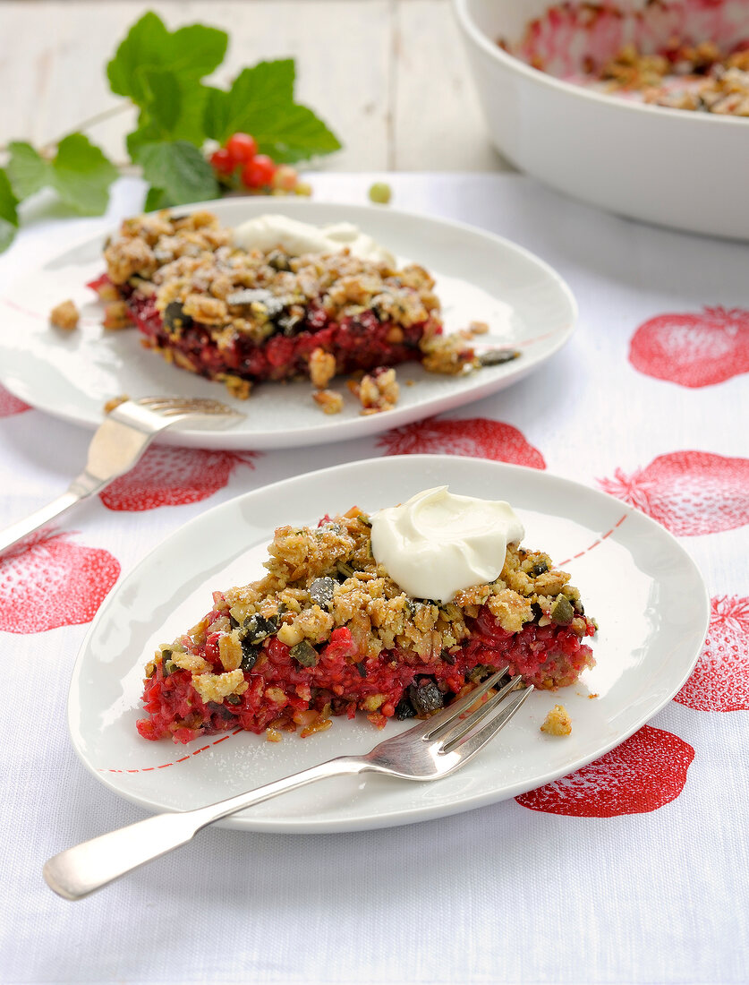 Berry crumble with cream on plate