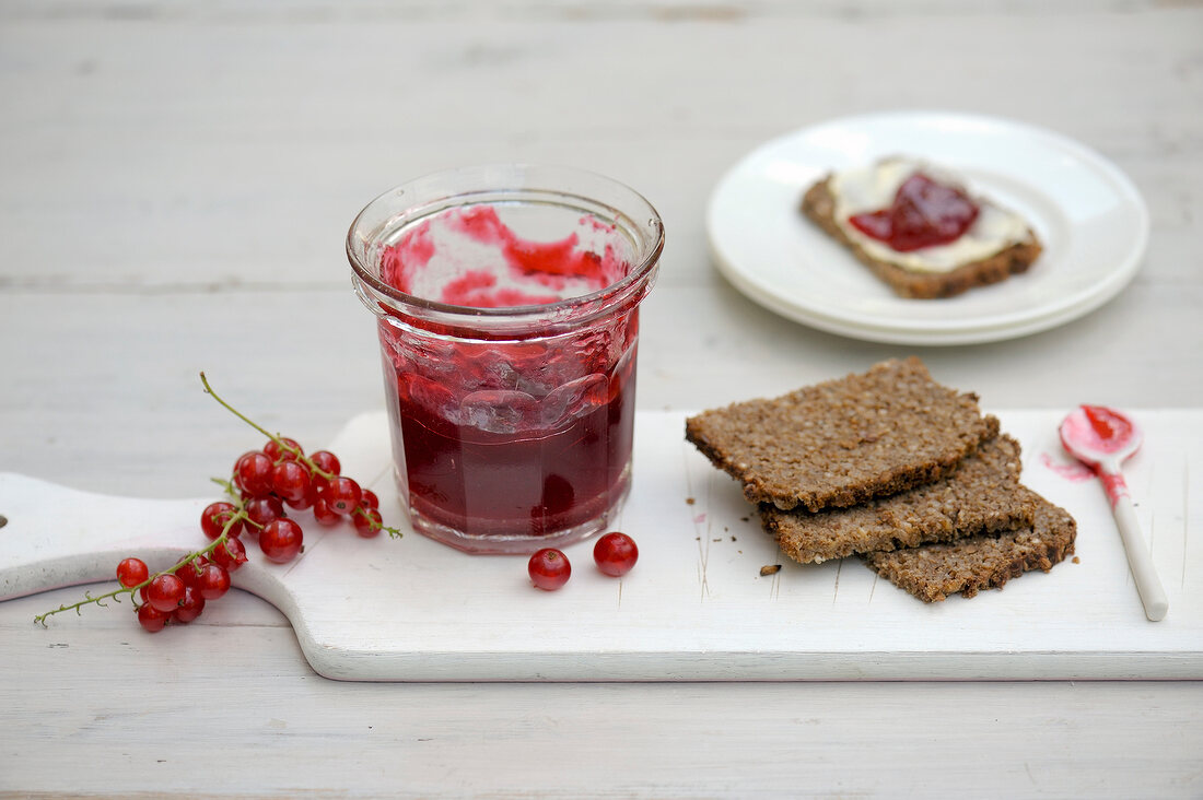 Bread with redcurrant jam on chopping board