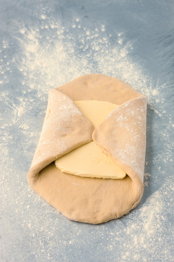 Butter pot on rolled dough for preparing pastry, step 2