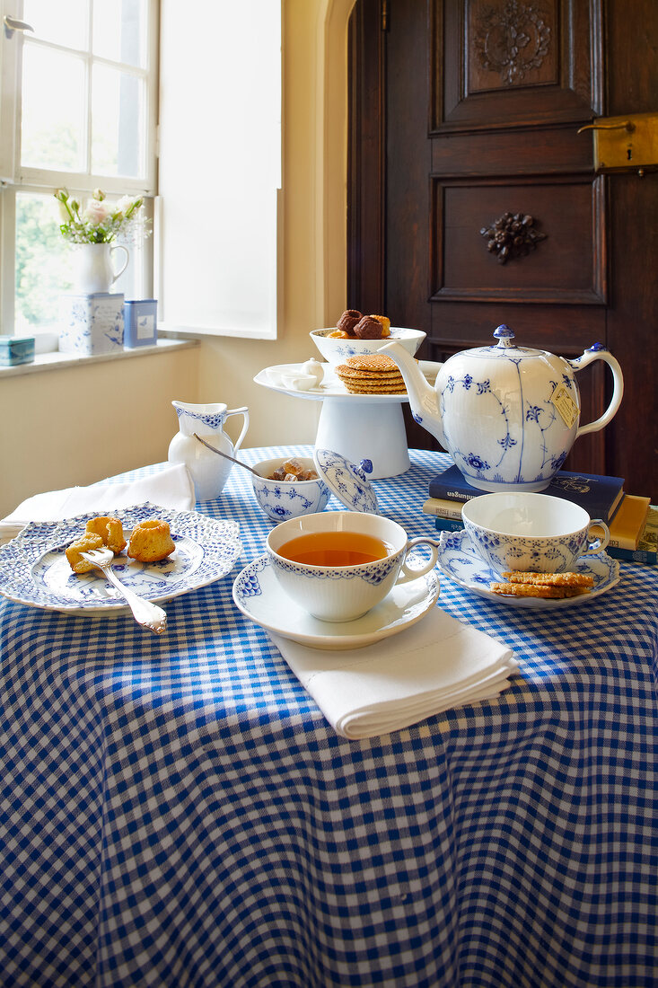 Coffee, tea, cake and jug on checkered tablecloth