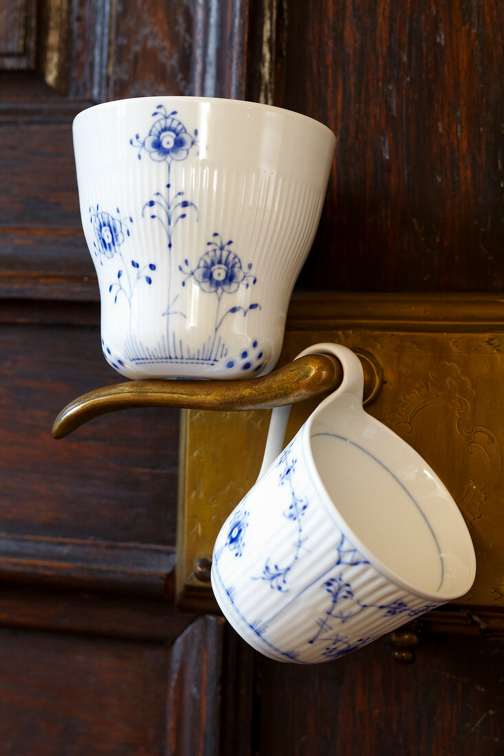 Close-up of cup and mug on a doorknob