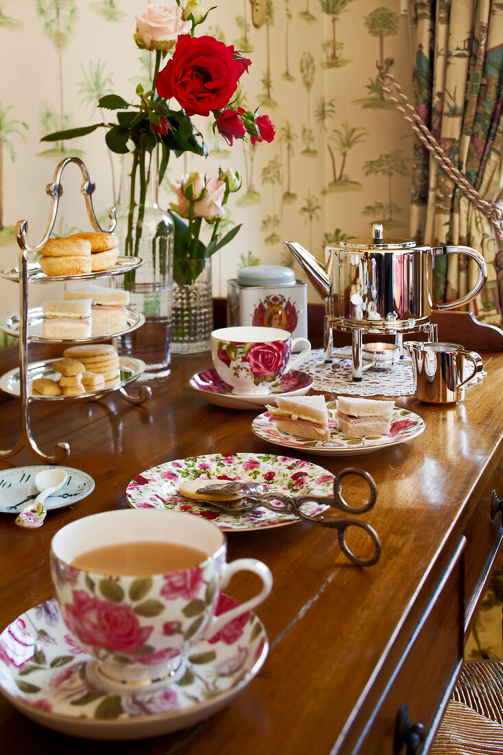 Tea set with roses on table set for tea time