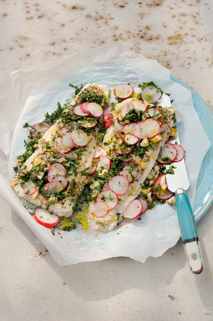 Steamed wurzfisch with radish on baking paper