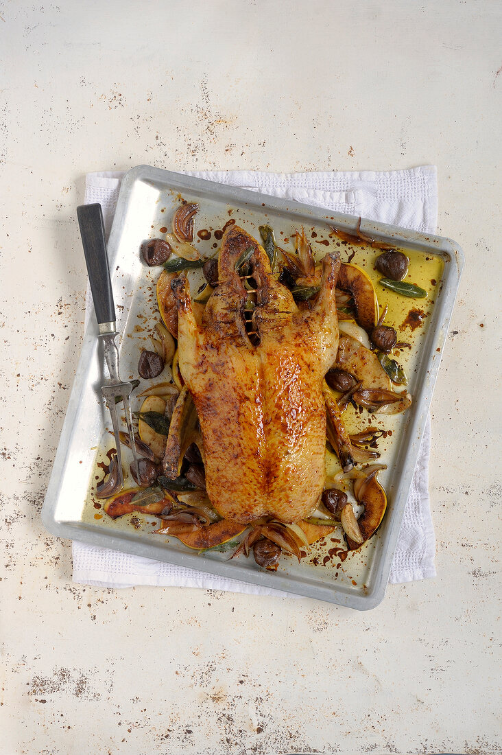 Duck with quince slice and chestnuts on baking dish