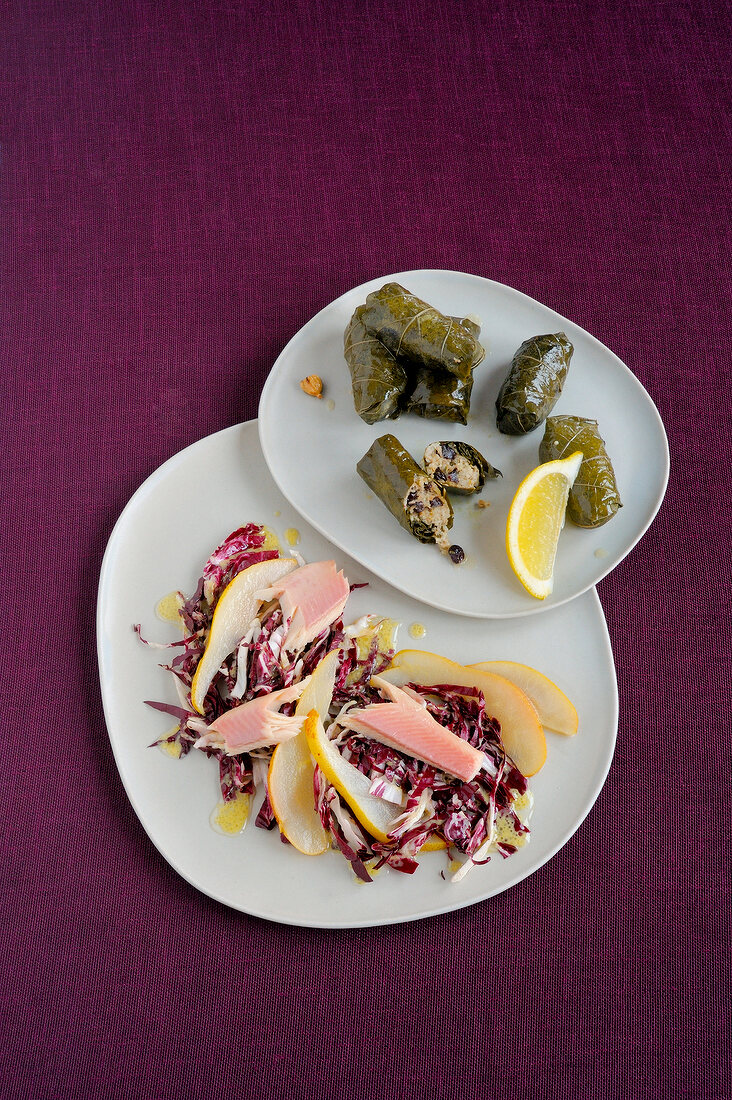 Stuffed grape leaves with pear slices and radicchio on plates