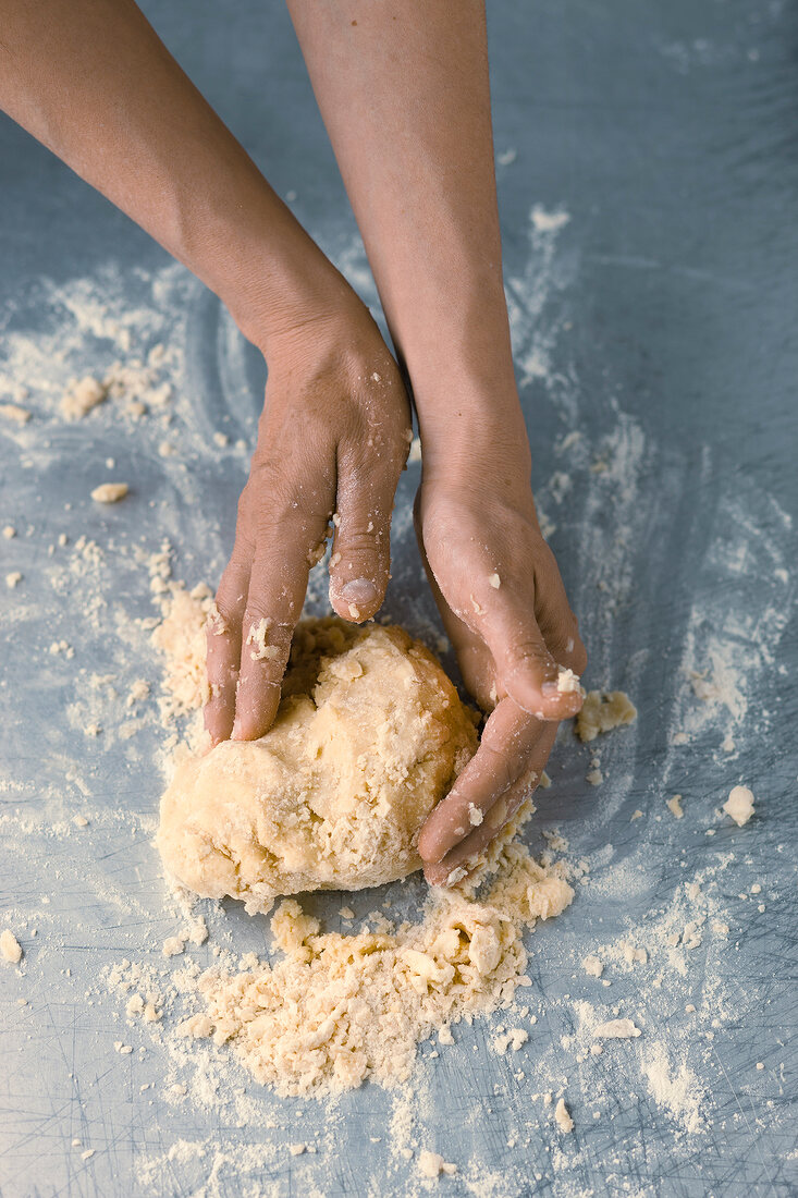 Close-up of hand kneading dough for preparation of short crust, step 3