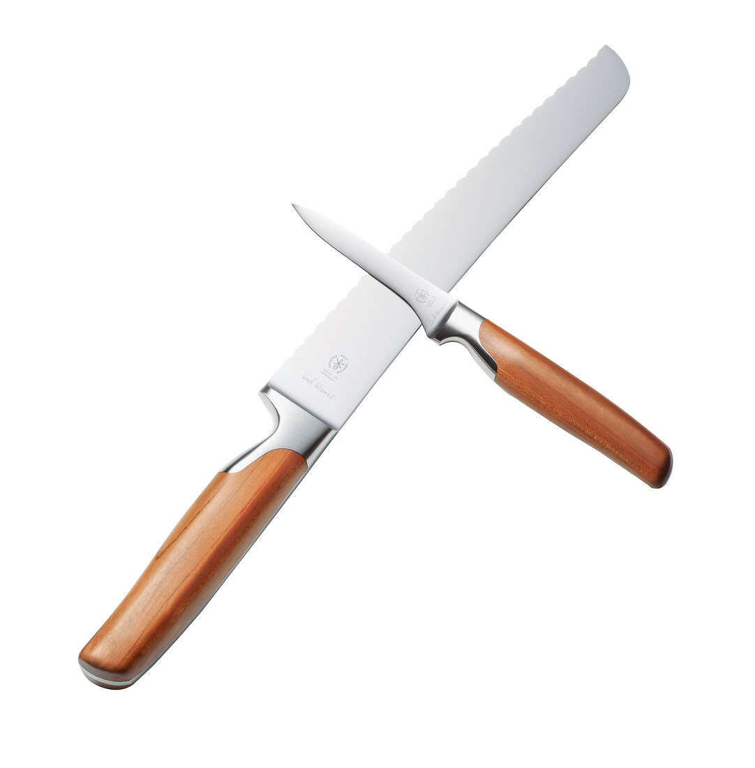 Knifes with plum wood handles crosswise on white background