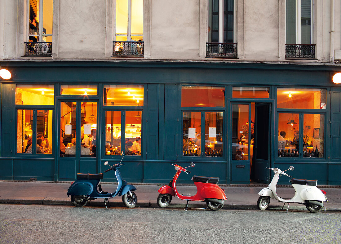 Row of vespas parked against exterior of Cafe Marly Restaurant, Paris