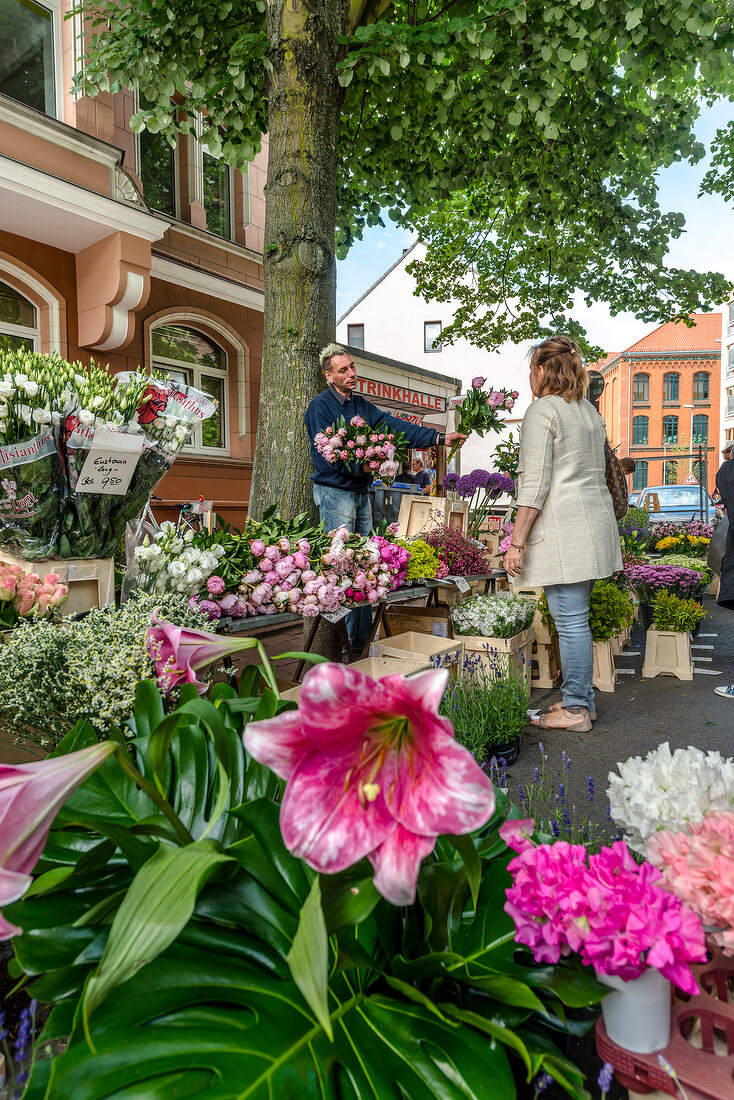 Woman buying flowers at Linden market in Hannover, Germany