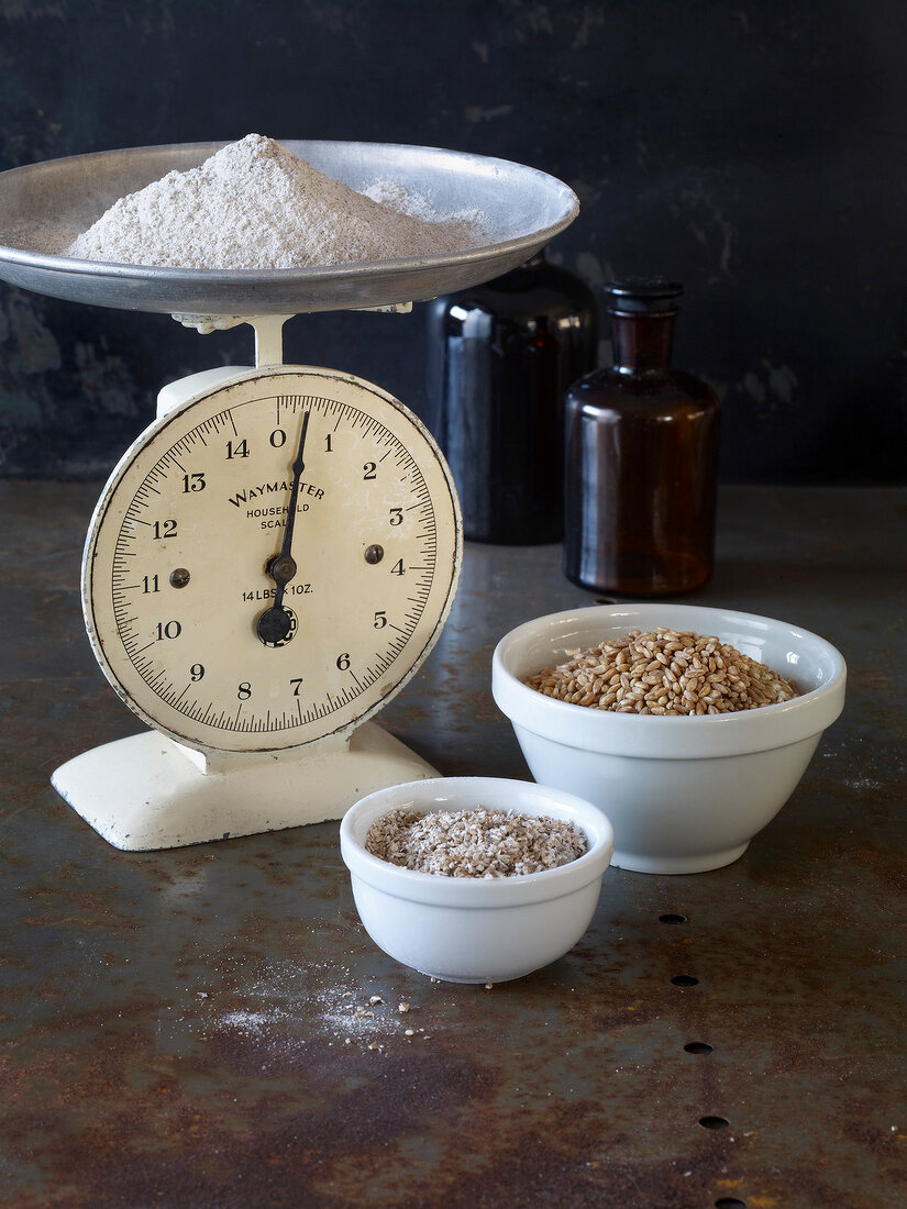 Brot, Schälchen mit Körner, Waage mit Mehl, weiß