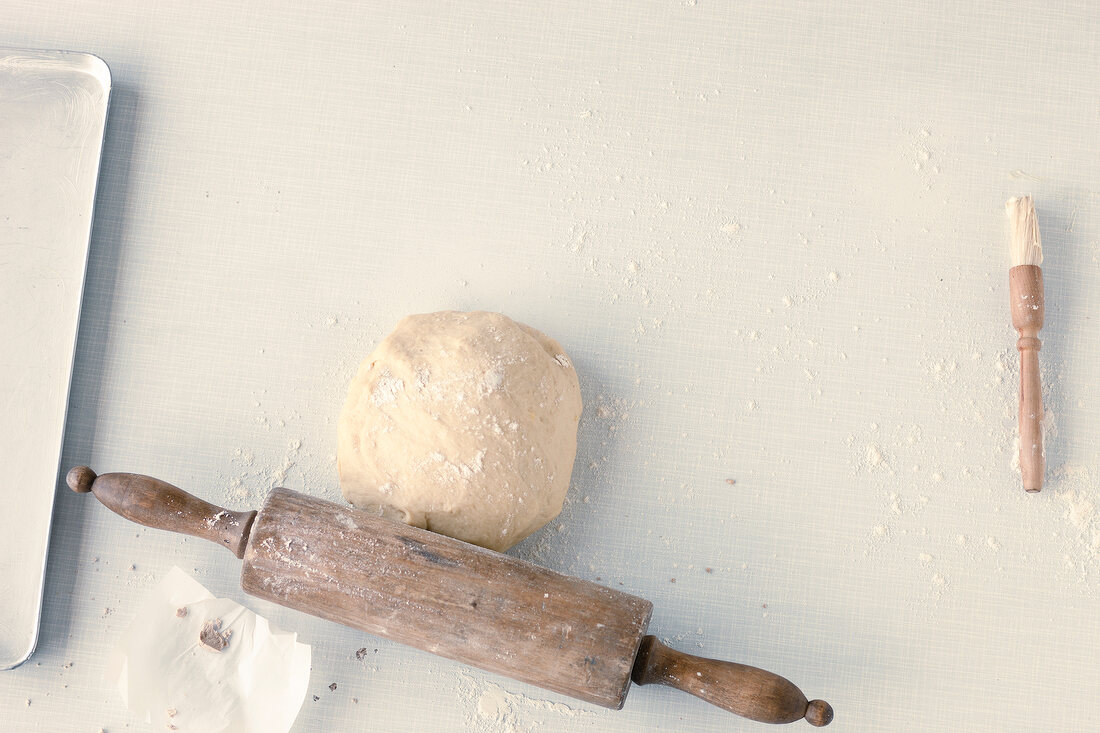Dough, rolling pin and food brush on white background