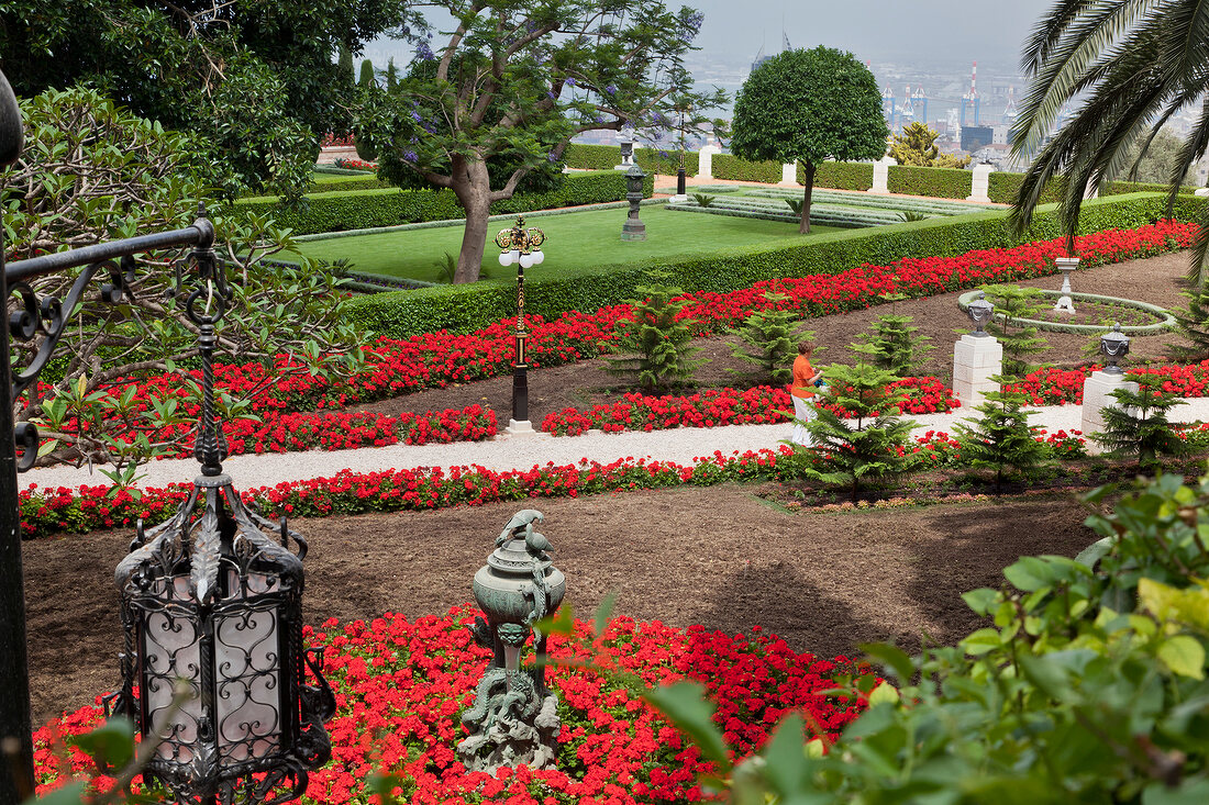 View of pebbles pavement with flower plant and palm trees at Bahai Garden, Haifa, Israel