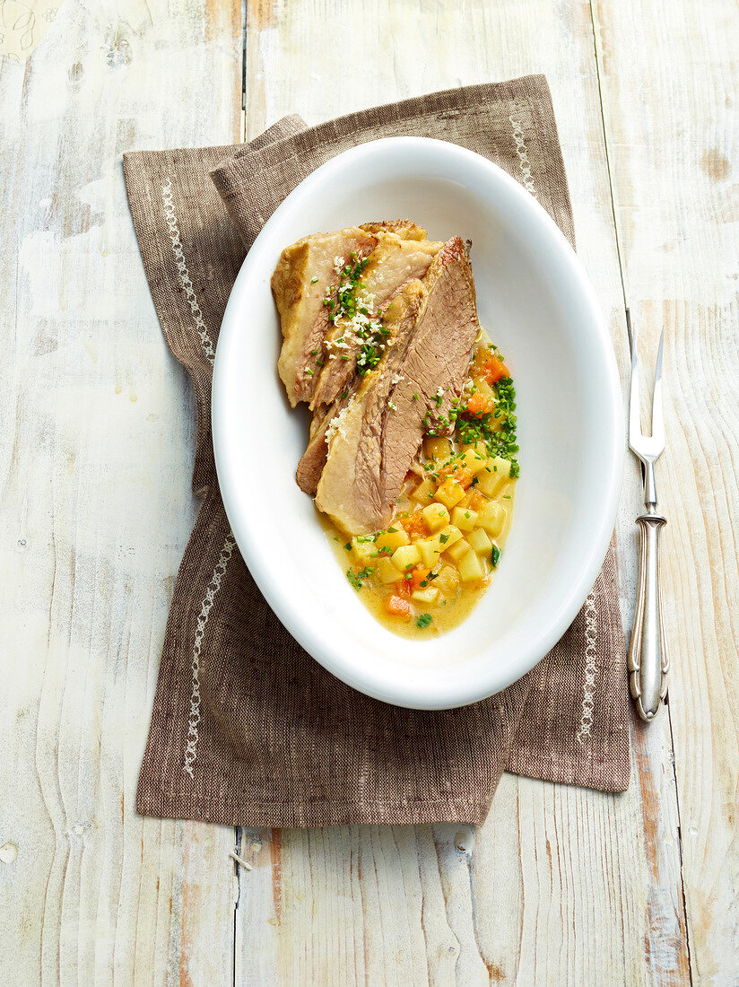 Cooked beef with pumpkin and stechruam on plate, Bavaria, Germany