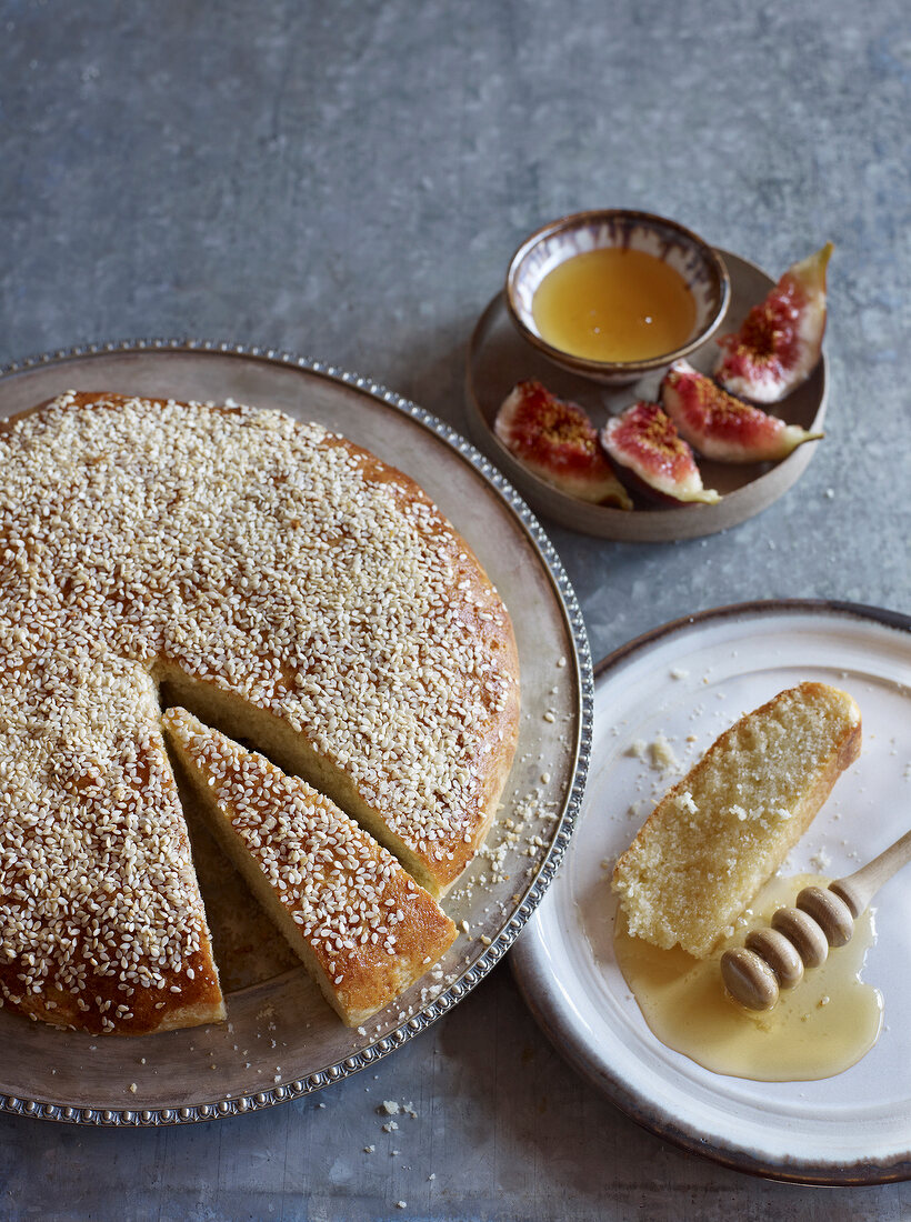 Sliced Tunisian semolina cakes on cake stand served with honey and figs on plate