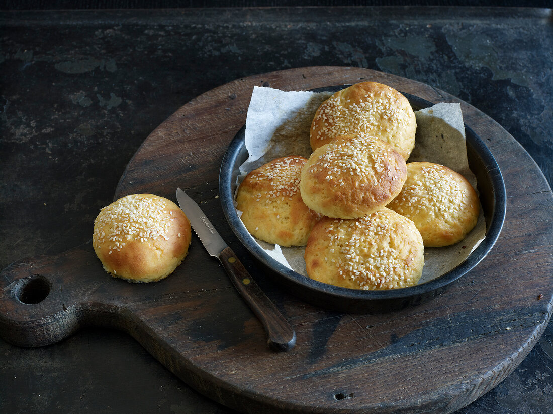 Hamburger buns with sesame seeds in baking tray